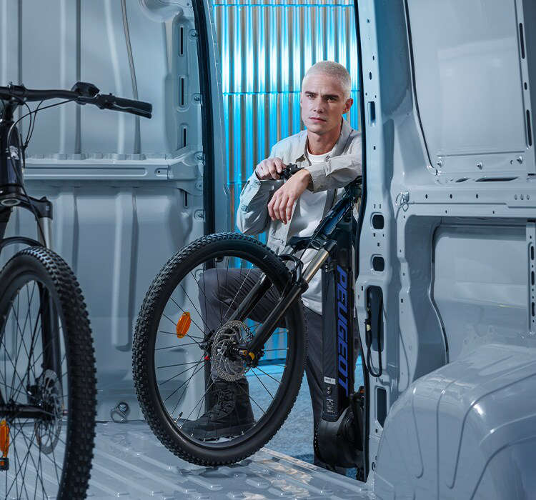 Чоловік завантажує велосипед у Peugeot Boxer