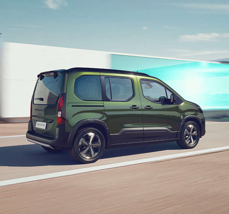 Peugeot e-Rifter зеленого кольору у русі, вигляд ззаду з правого боку